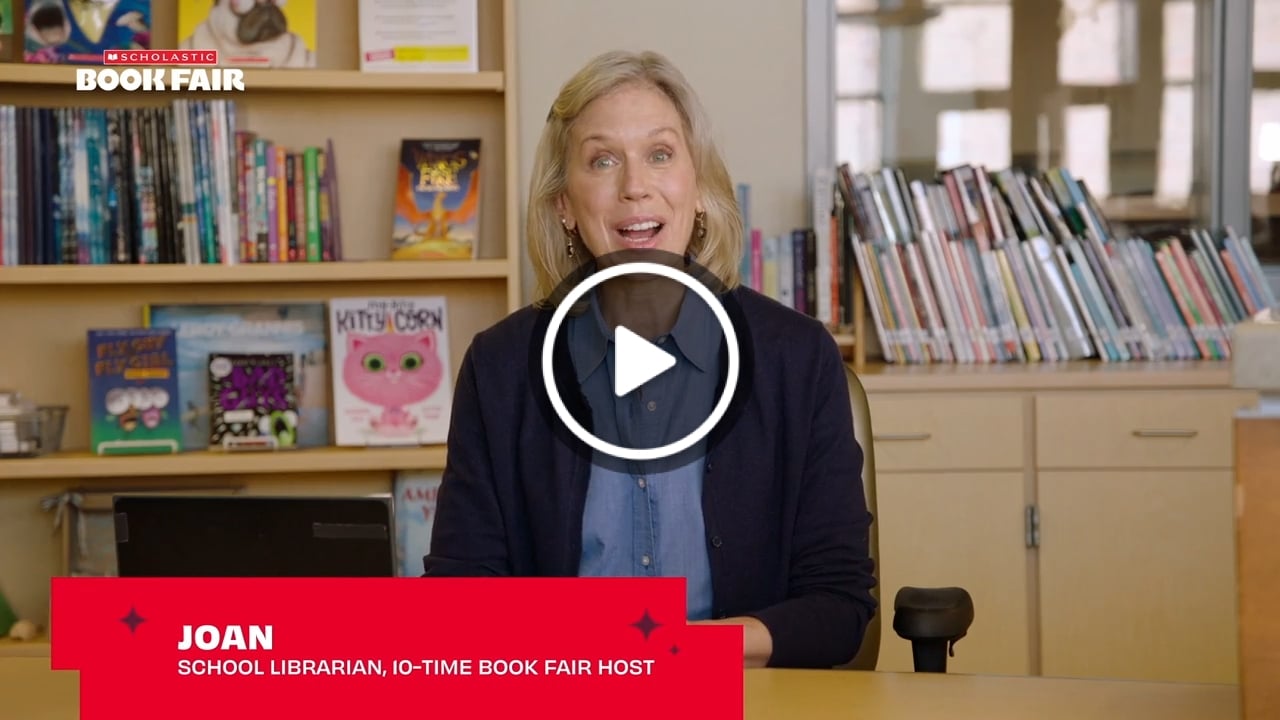 Host/school librarian sits behind a desk and Scholastic books
